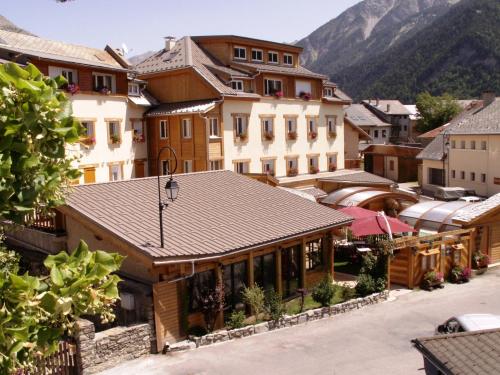 Vistas a una ciudad con montañas en el fondo en Hôtel Restaurant & Spa Les Autanes, en Ancelle