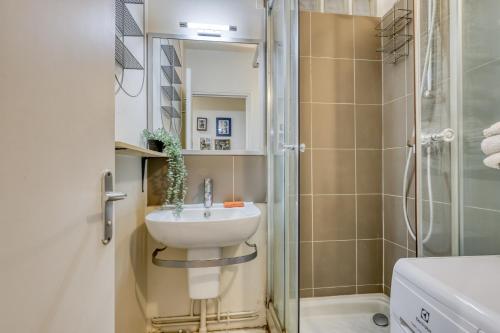 une salle de bain avec un lavabo et une douche dans l'établissement Classic & Charming Parisian flat - Luxury 16th, à Paris