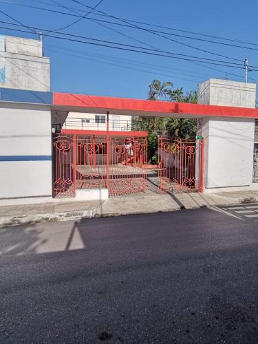 un cancello rosso davanti a un distributore di benzina di Mares a Tizimín