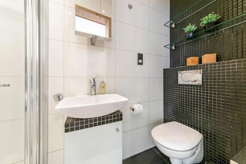 a white bathroom with a sink and a toilet at 1 Bedroom Edgeware Retreat in London