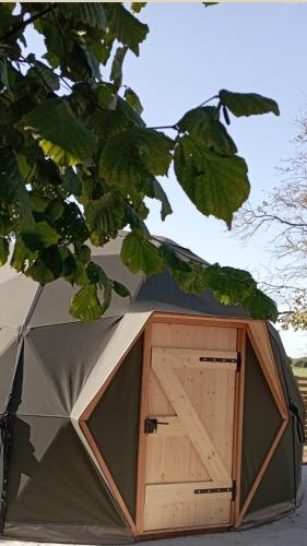eine Tür in einem Zelt unter einem Baum in der Unterkunft Dôme Cocon des Cabris in Bérig-Vintrange