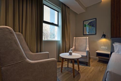 a living room with two chairs and a table at Aurum Keys By VYDA in Bengaluru