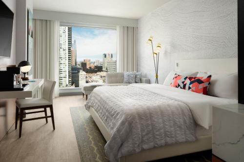 a bedroom with a bed and a desk and a window at Le Méridien Denver Downtown in Denver