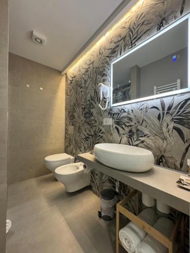 a bathroom with two toilets and a sink and a mirror at Lina suites & rooms in La Spezia