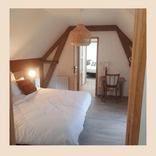 um quarto com uma cama branca num sótão em Au vert des lys Overkoken em Haverskerque