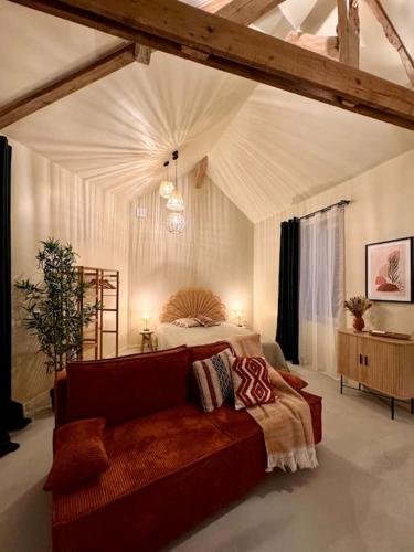 1 dormitorio con cama y sofá en Charmant loft intime, en Croisy-sur-Eure