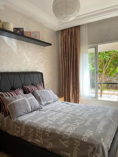 a bedroom with a large bed and a window at RICO FLORES PALM BENSLIMANE in Mohammedia