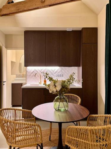 une cuisine avec une table avec un vase de fleurs dessus dans l'établissement Charmant loft intime, à Croisy-sur-Eure