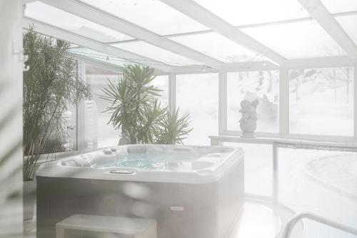 een witte badkamer met een bad en een raam bij Hotel Sonklarhof in Ridanna