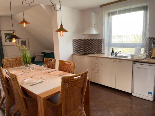 a kitchen with a table with chairs and a dining room at Apartamenty Prima in Dziwnówek