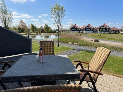 uma mesa e cadeiras com uma garrafa de bebida em Fantastisk lejebolig med direkte udsigt til sø em Bogense