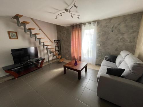 a living room with a couch and a table at CAMILLE à VER SUR MER in Ver-sur-Mer