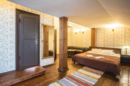 1 dormitorio con cama, espejo y puerta en Alatskivi Castle, en Alatskivi