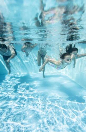 a group of people swimming in the water at Villa celine in Aliki