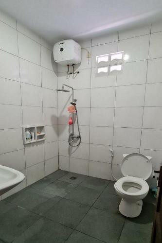 a bathroom with a toilet and a shower at Rumah Kalimanjung in Ngingas