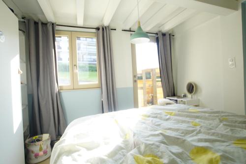 une chambre avec un grand lit blanc avec une fenêtre dans l'établissement le Cloumel Appt 8 pers 120 m terrasse 60m plein centre vue montagne, à Combloux