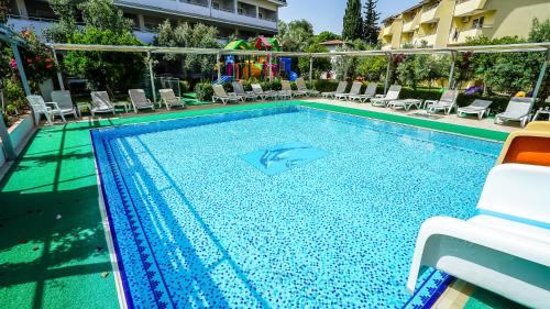 a swimming pool with chairs and a swimming pool at Catty Cats Garden Hotel in Side