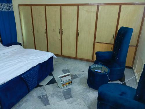 1 dormitorio con 1 cama, 2 sillas y mesa en Prime Family Lodge, en Rawalpindi