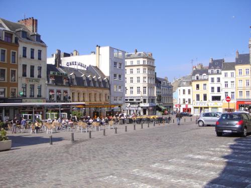 une rue dans une ville avec des personnes assises sur des chaises dans l'établissement Une escale à Boulogne - Appartement au coeur de la ville avec Parking privé, à Boulogne-sur-Mer