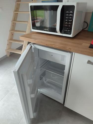 un four micro-ondes installé au-dessus d'un comptoir de cuisine dans l'établissement Maison de bourg équipée à 20mn du Puy du Fou - 4 pers, à Bazoges-en-Paillers