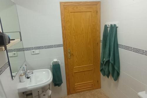 a bathroom with a sink and a wooden door at adosado con piscina en Cabo de Gata 6p in El Cabo de Gata