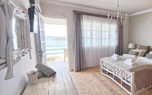 a bedroom with a bed and a view of the ocean at Le Grand Bleu Studios & Apartments in Lefkos Karpathou