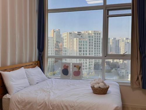 Seoul-lo Apartment في سول: سرير في غرفة مع نافذة كبيرة