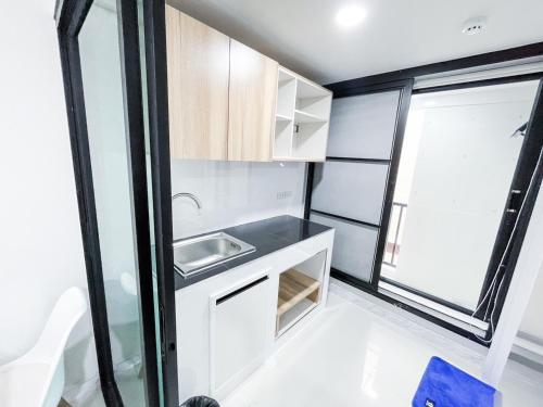 una pequeña cocina con fregadero y ventana en S&Y Apartment en Ban Nong Waeng