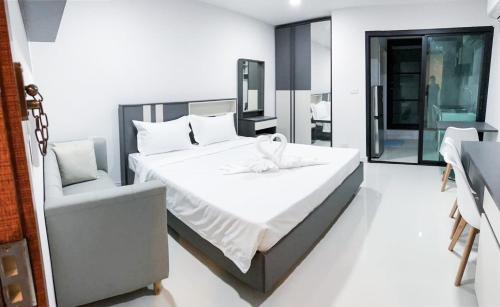 a bedroom with a large bed and a chair at S&Y Apartment in Ban Nong Waeng