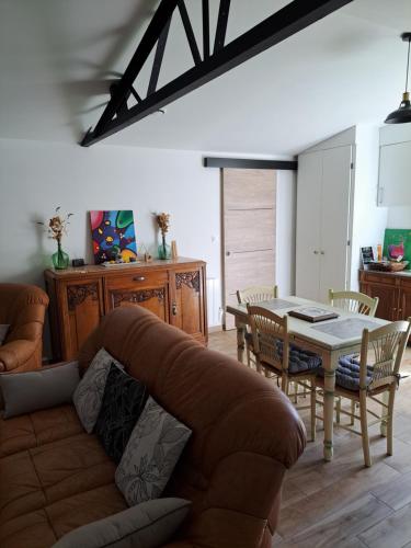 a living room with a couch and a table at Gîte Les Cerisiers Sud-Gironde dans le Sauternais meublé de tourisme 3 étoiles in Preignac