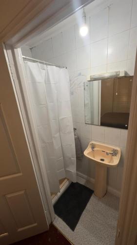 y baño con lavabo y ducha con espejo. en Triple Room Clontarf House-2 en Dublín