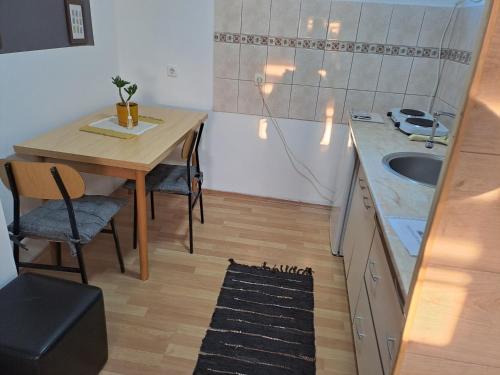 a kitchen with a wooden table and a sink at Apartman 1 - Banoštor in Banoštor