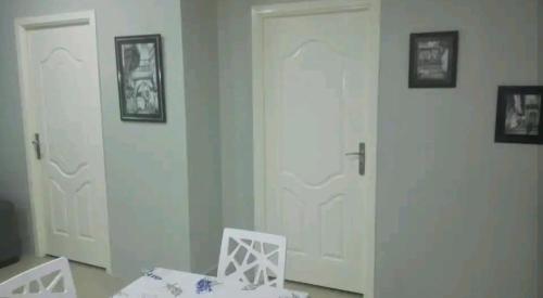 a room with two white doors and a white chair at Hydra Résidence Privée in Hydra