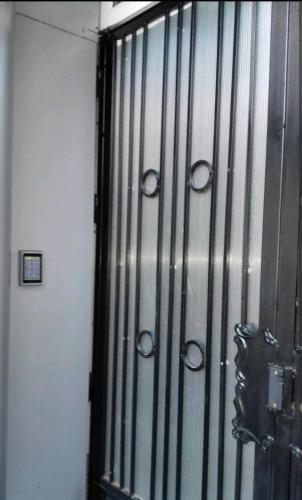 a metal door of a prison cell with handcuffs at Hydra Résidence Privée in Hydra