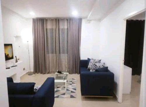 a living room with a blue couch and a table at Hydra Résidence Privée in Hydra
