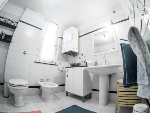 a white bathroom with a sink and a toilet at Blue Room Shared House Terrace above in Genoa