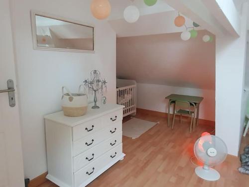 a bedroom with a white dresser and a crib at Charmante maison au bord des falaises in Les Authieux-sur-le-Port-Saint-Ouen