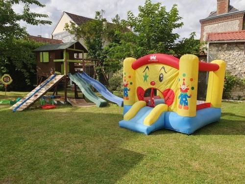 a playground with a slide in the grass at Charmante maison au bord des falaises in Les Authieux-sur-le-Port-Saint-Ouen