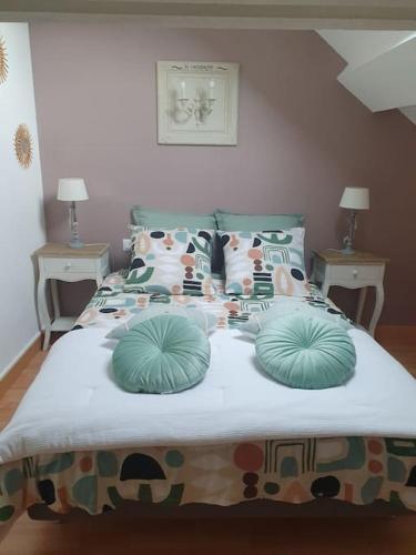 un lit avec des oreillers dessus dans une chambre dans l'établissement Charmante maison au bord des falaises, à Les Authieux-sur-le-Port-Saint-Ouen