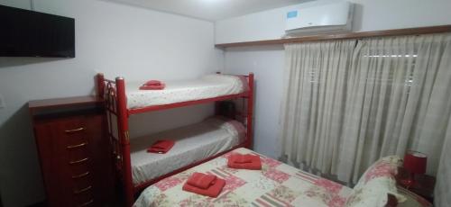 a small room with two bunk beds and a tv at Balcón del Mar in Monte Hermoso