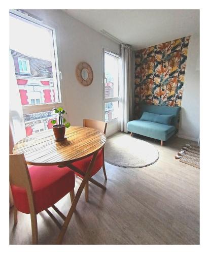 un salon avec une table et un canapé bleu dans l'établissement Studio Chemin Bleu, à Lourdes