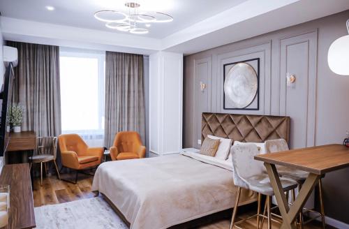 um quarto com uma cama, uma mesa e cadeiras em New Oasis Premier-Inn flats em Chisinau