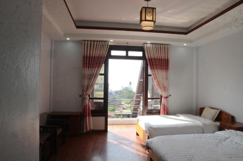 - une chambre avec 2 lits et une grande fenêtre dans l'établissement MÂY NÚI SA PA, à Sa Pa