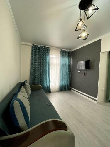 1 dormitorio con 1 cama y TV en Ak Line en Bosteri