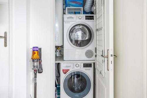 a laundry room with a washer and a dryer at ParisMyHome - AIR COND, 2 SHOWERS, 2 WC in Paris