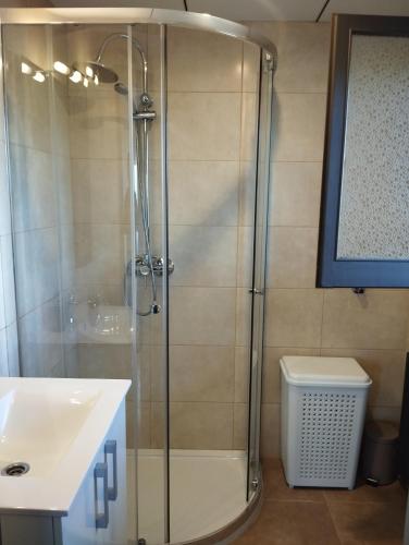 a shower with a glass door next to a sink at Bella Terra in L'Ampolla