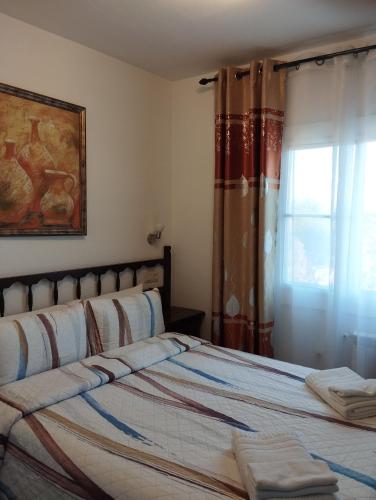 a bedroom with a bed and a window with curtains at Bella Terra in L'Ampolla