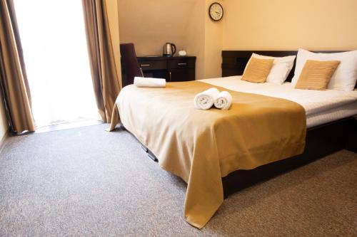 a hotel room with a bed with two towels on it at Hotel Diplomat in Tbilisi City