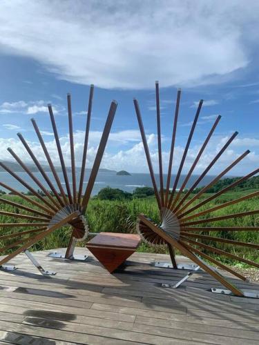 a group of wooden structures with a view at Studio TI PLEZI 26m a 2 pas Marina du Marin climatisé parking in Le Marin