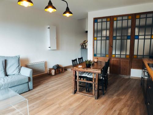 ein Wohnzimmer mit einem Tisch und einem Sofa in der Unterkunft Gîte de l'atelier in Saint-Privat